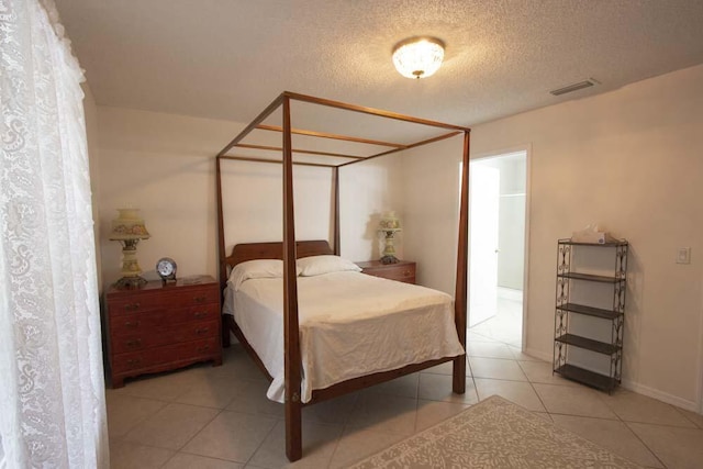 bedroom featuring tile patterned flooring and a textured ceiling