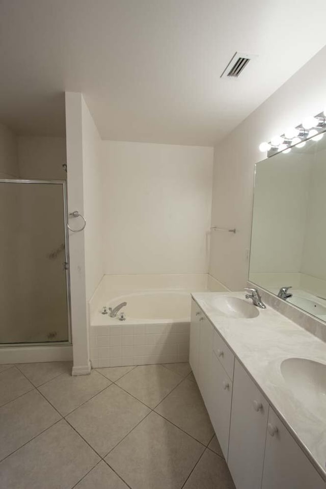 full bathroom featuring tile patterned flooring, a bath, a stall shower, and double vanity
