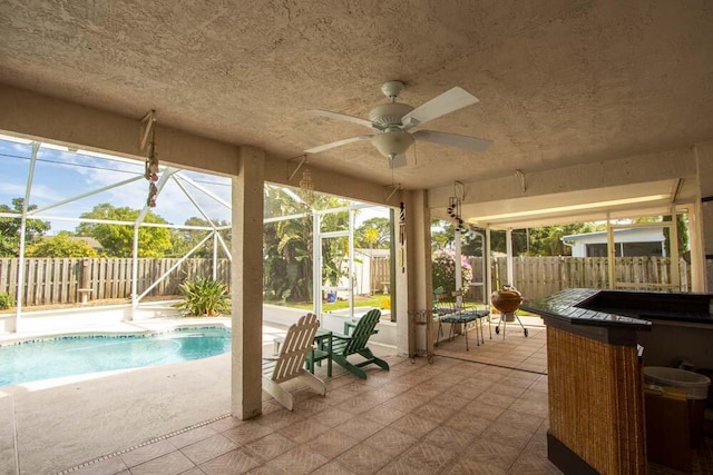 view of patio / terrace with a fenced backyard, ceiling fan, and glass enclosure