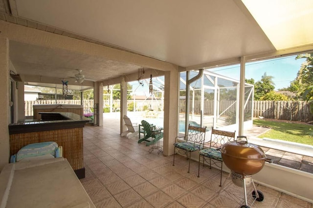 view of patio with a fenced backyard, a lanai, and a ceiling fan