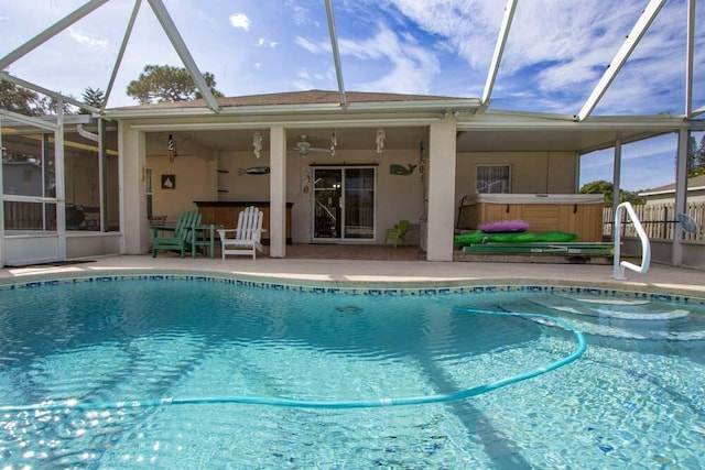 outdoor pool with a patio area, a lanai, and a hot tub
