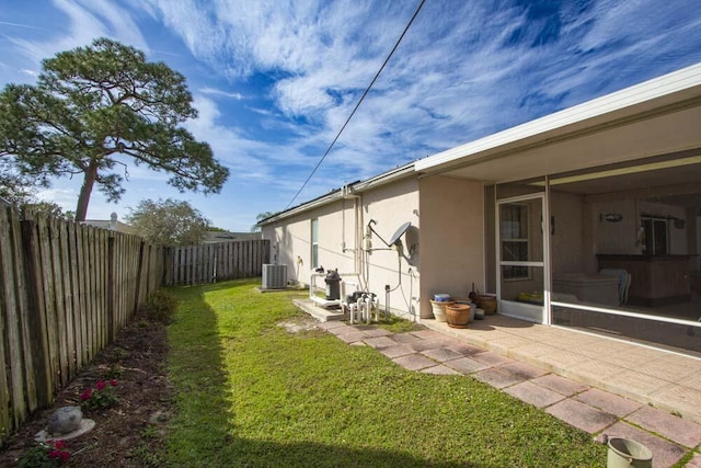 view of yard featuring central air condition unit and a patio