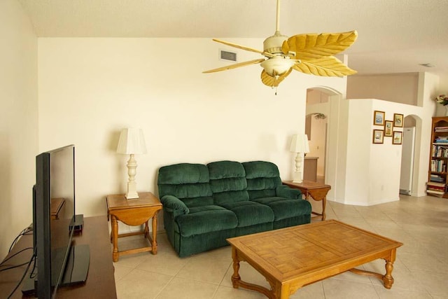 living room featuring arched walkways, light tile patterned floors, and a ceiling fan