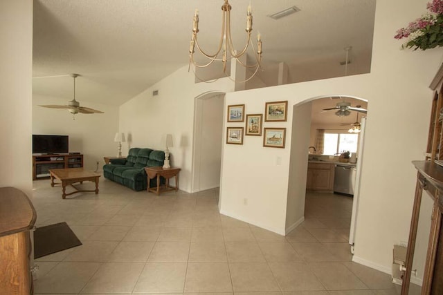 living area featuring arched walkways, ceiling fan, light tile patterned floors, high vaulted ceiling, and baseboards