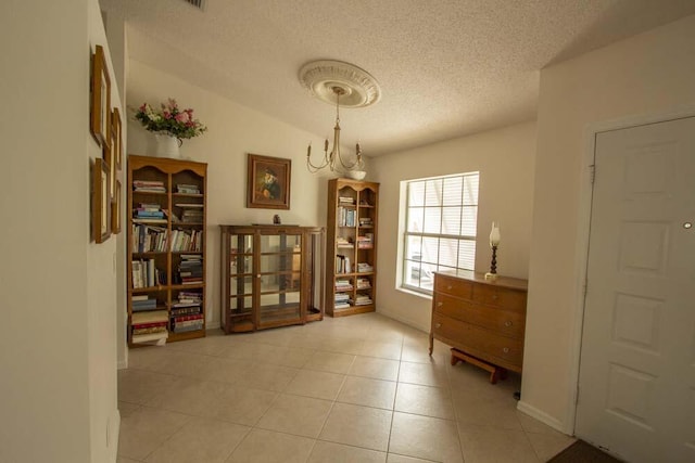 living area with a textured ceiling and light tile patterned flooring