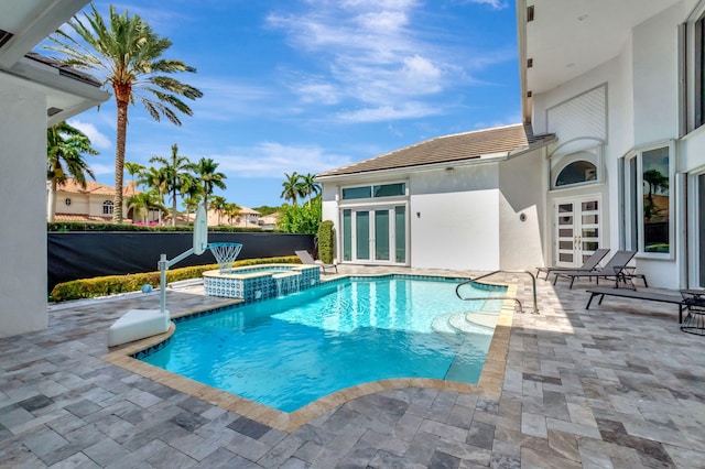 view of pool with french doors, a patio area, and a pool with connected hot tub