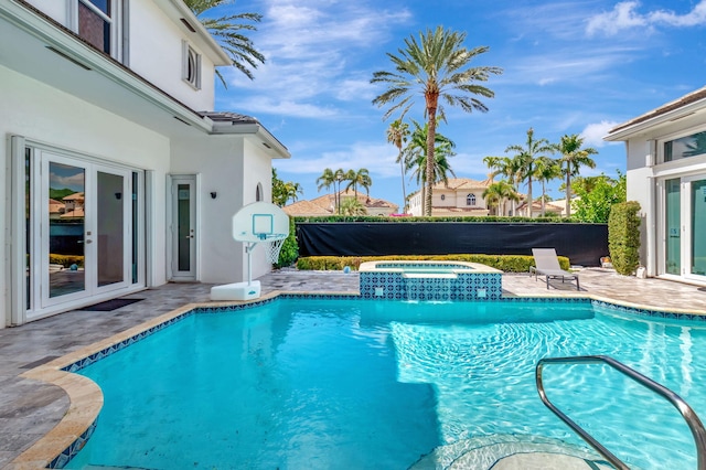 view of swimming pool featuring french doors, a patio area, and a pool with connected hot tub