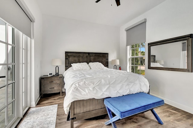bedroom featuring wood finished floors, baseboards, and ceiling fan