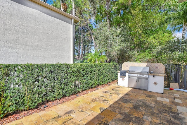 view of patio / terrace featuring an outdoor kitchen, a grill, and fence