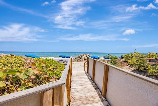 view of property's community with view of water and beach