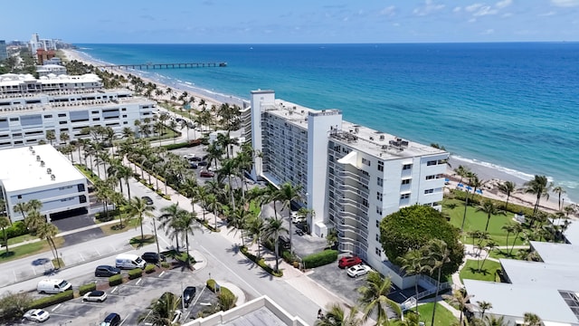 aerial view of waterfront with a beach and apartment complex