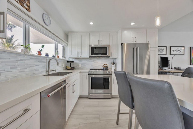 kitchen featuring appliances with stainless steel finishes, a sink, white cabinetry, and recessed lighting