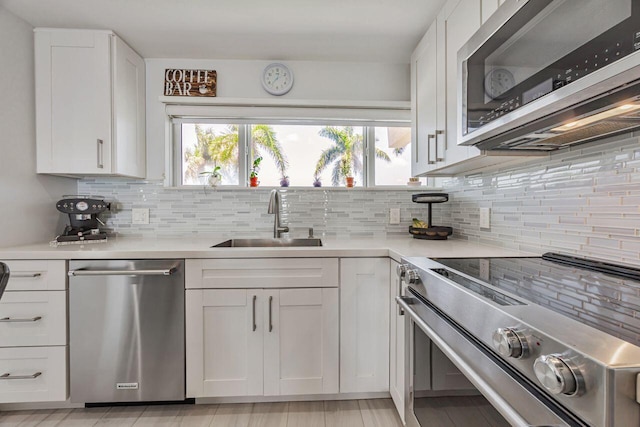 kitchen featuring appliances with stainless steel finishes, a sink, and white cabinets