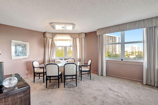 dining room with carpet flooring, a chandelier, a textured ceiling, healthy amount of natural light, and baseboards