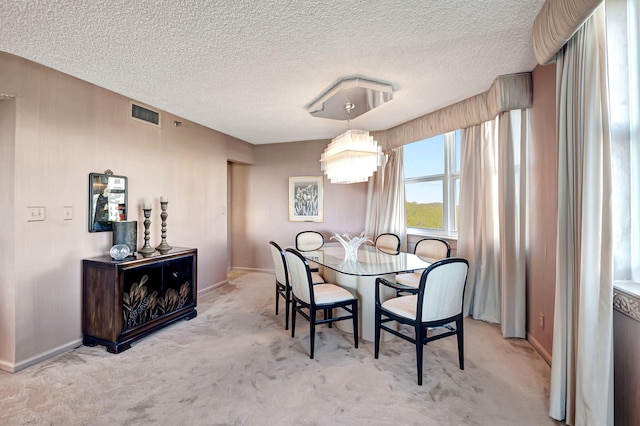 carpeted dining area with baseboards, a textured ceiling, and a chandelier