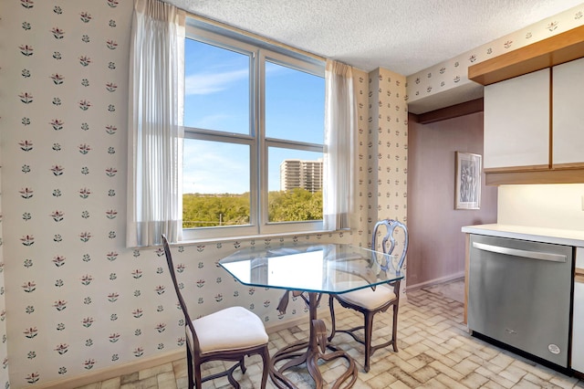 dining room with wallpapered walls, brick patterned floors, baseboards, and a textured ceiling