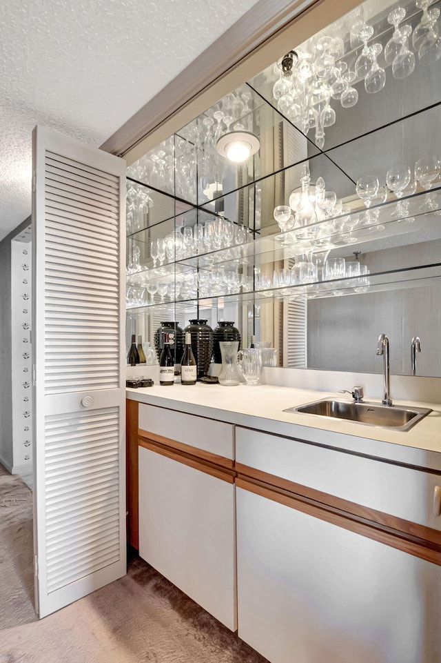 indoor wet bar featuring a textured ceiling and light carpet