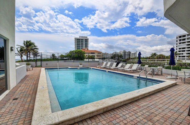 community pool with fence and a patio