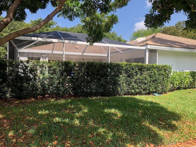 view of green lawn with glass enclosure