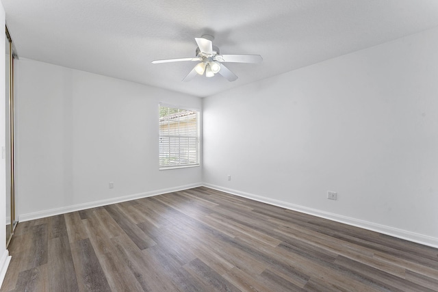 unfurnished room with dark wood-style flooring, baseboards, and a ceiling fan