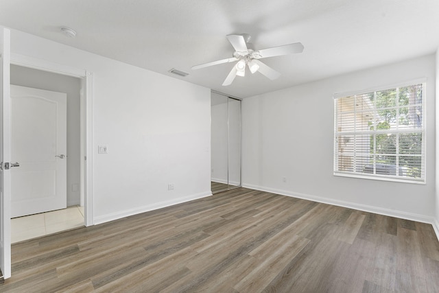 empty room featuring wood finished floors, ceiling fan, and baseboards