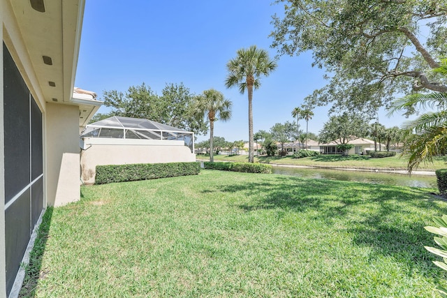 view of grassy yard featuring a lanai