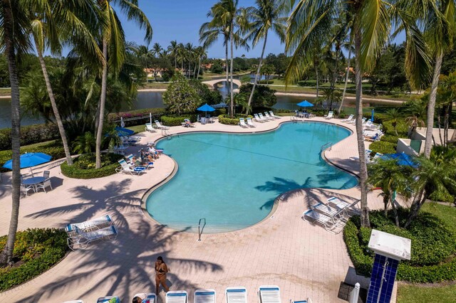 community pool with a water view and a patio area