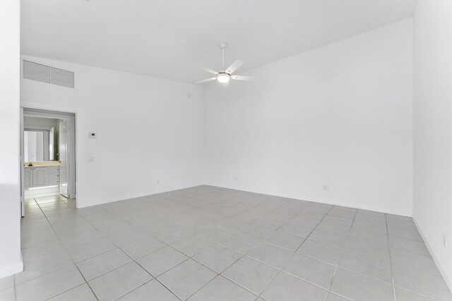 empty room with ceiling fan and light tile patterned floors