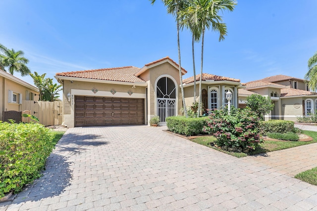 4911 Tropical Garden Dr, Boynton Beach, FL 33436 - mediterranean / spanish house featuring stucco siding, an attached garage, decorative driveway, and a tile roof
