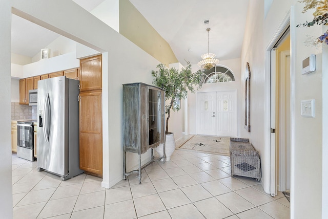 4911 Tropical Garden Dr, Boynton Beach, FL 33436 - entrance foyer featuring a chandelier, light tile patterned flooring, and high vaulted ceiling
