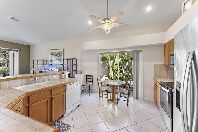 4911 Tropical Garden Dr, Boynton Beach, FL 33436 - kitchen featuring stainless steel appliances, tile countertops, healthy amount of natural light, decorative backsplash, and recessed lighting