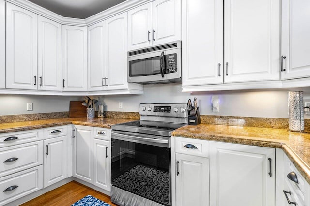 507 SW 17th St, Fort Lauderdale, FL 33315 - kitchen with stainless steel appliances, white cabinets, and light wood finished floors
