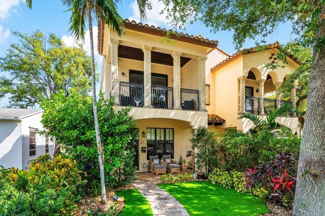 507 SW 17th St, Fort Lauderdale, FL 33315 - back of property featuring a balcony, a tile roof, stucco siding, and a lawn