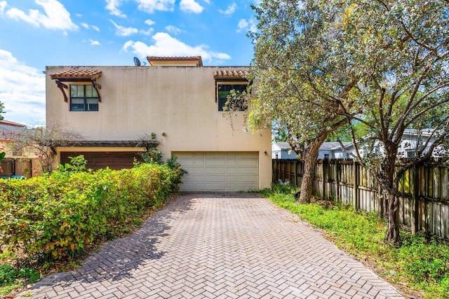 507 SW 17th St, Fort Lauderdale, FL 33315 - view of front facade with a garage, decorative driveway, fence, stucco siding, and a tile roof