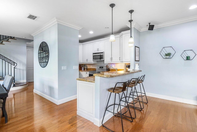 507 SW 17th St, Fort Lauderdale, FL 33315 - kitchen with appliances with stainless steel finishes, baseboards, a breakfast bar, light wood-style flooring, and crown molding