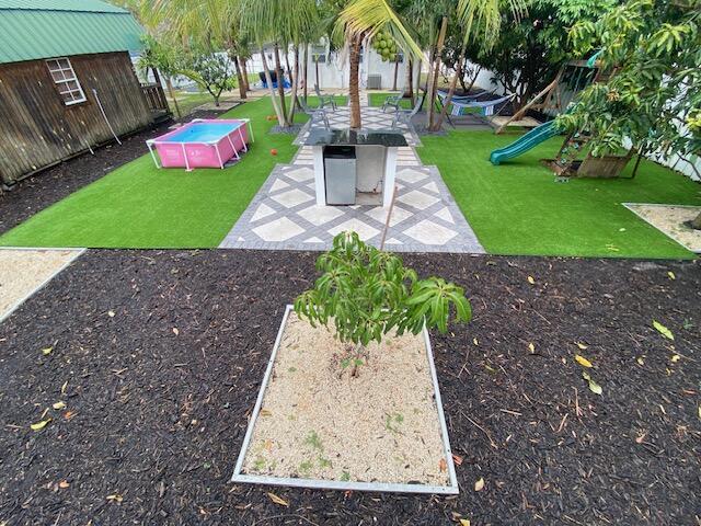 1119 S Ridge St, Lake Worth, FL 33460 - view of green lawn with a playground and a patio