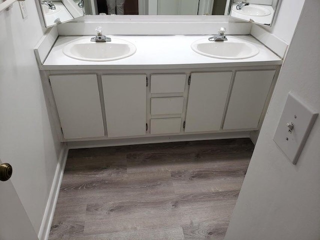 bathroom with double vanity and wood finished floors