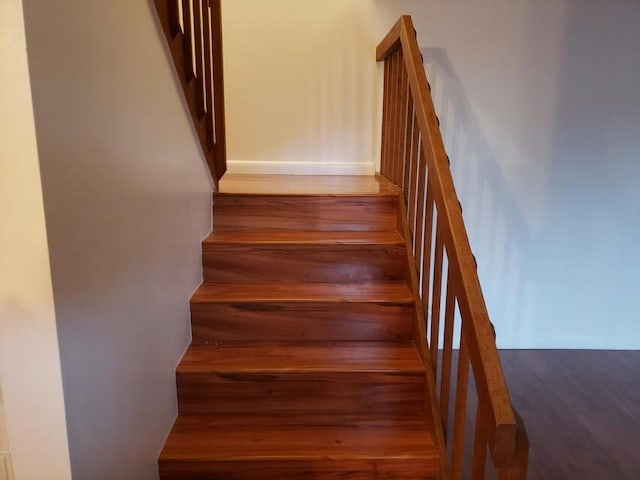 stairs with wood finished floors and baseboards