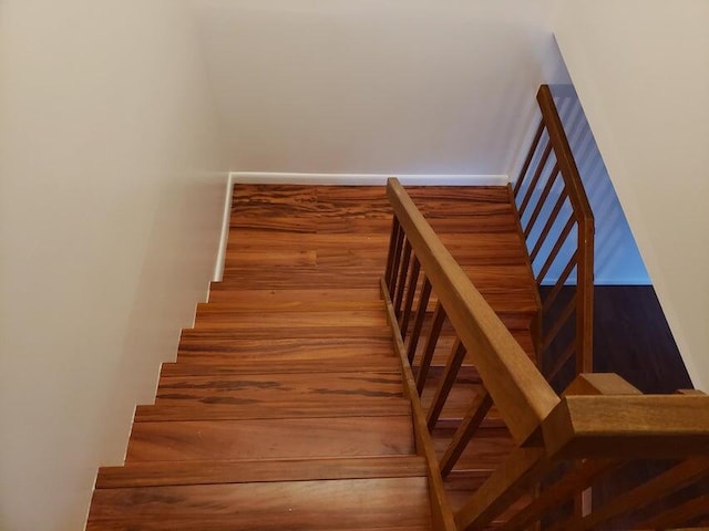 stairs featuring wood finished floors and baseboards
