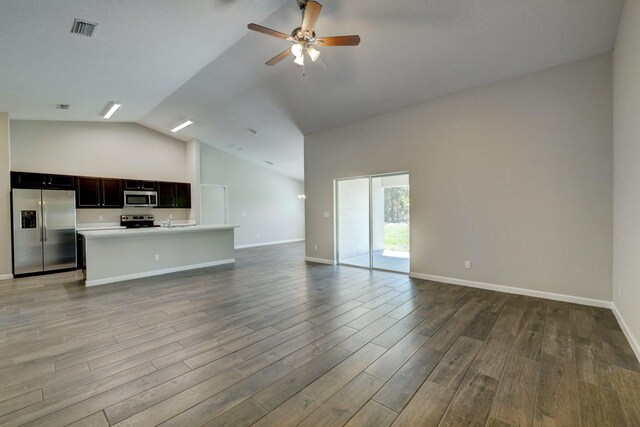 unfurnished living room featuring vaulted ceiling, a ceiling fan, wood finished floors, and baseboards