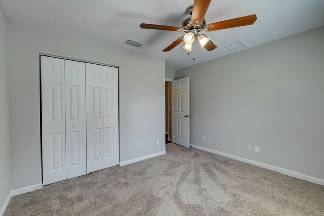 unfurnished bedroom featuring carpet flooring, a closet, baseboards, and ceiling fan