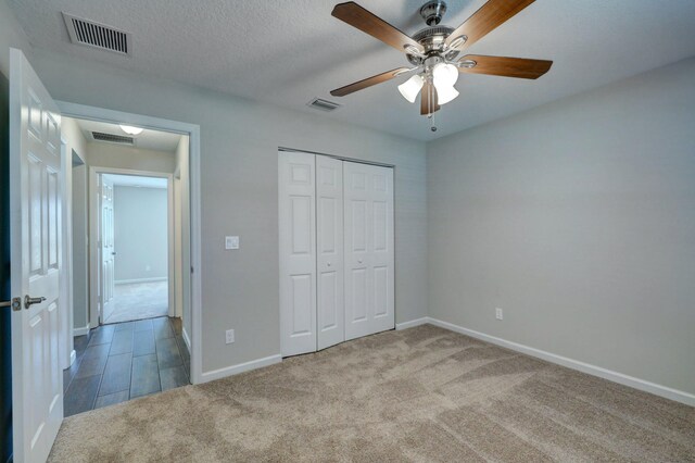 unfurnished bedroom with carpet floors, baseboards, a closet, and a ceiling fan