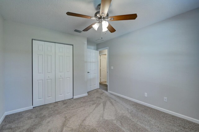 unfurnished bedroom featuring carpet floors, baseboards, a closet, and ceiling fan