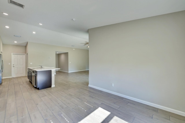 5800 NW Whitecap Rd, Port Saint Lucie, FL 34986 - kitchen with open floor plan, light wood-type flooring, a sink, baseboards, and freestanding refrigerator