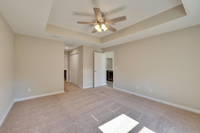 5800 NW Whitecap Rd, Port Saint Lucie, FL 34986 - spare room with a raised ceiling, light carpet, baseboards, and ceiling fan