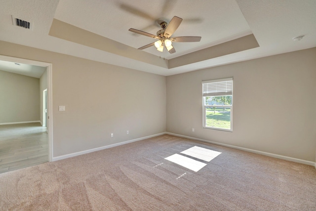 5800 NW Whitecap Rd, Port Saint Lucie, FL 34986 - unfurnished room featuring a tray ceiling, light carpet, ceiling fan, and baseboards