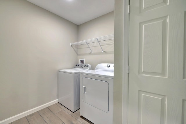 5800 NW Whitecap Rd, Port Saint Lucie, FL 34986 - clothes washing area featuring washer and clothes dryer, light wood-style flooring, and baseboards
