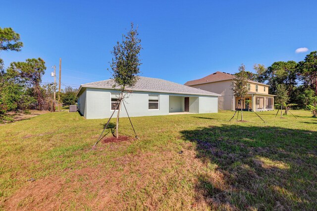 5800 NW Whitecap Rd, Port Saint Lucie, FL 34986 - rear view of property featuring a yard and stucco siding