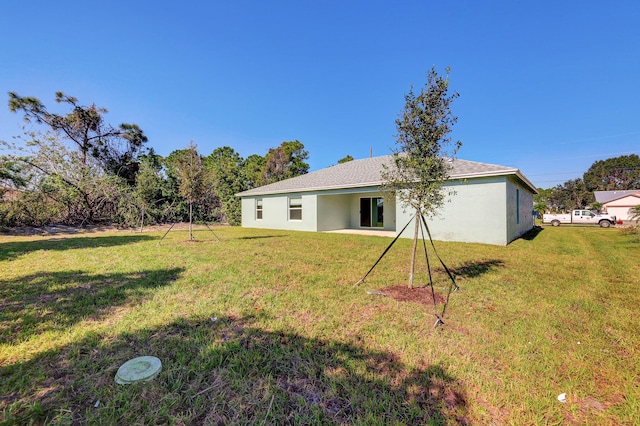5800 NW Whitecap Rd, Port Saint Lucie, FL 34986 - rear view of property featuring a yard and stucco siding