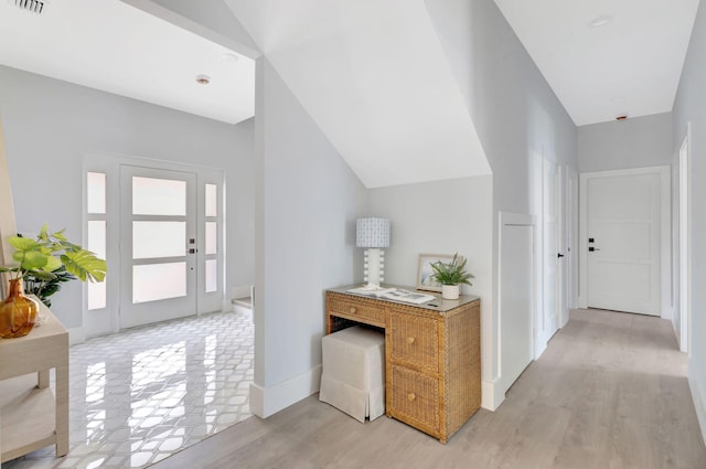 hallway featuring light wood-type flooring and lofted ceiling
